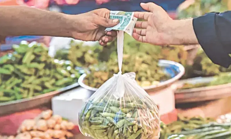 A photo of a man purchasing vegetables and exchanging money. — AFP/File A photo of a man purchasing vegetables and exchanging money. — AFP/File