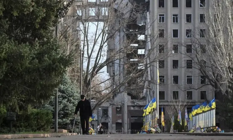 A man walks next to a damaged building, amid Russia’s attack on Ukraine, in Mykolaiv, Ukraine on November 27. —Reuters