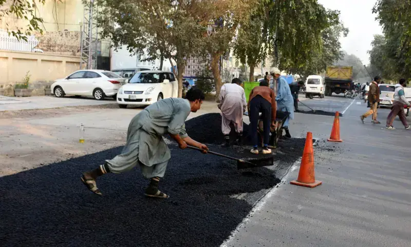 NHA workers repair a damaged section of Allama Iqbal Road in Lahore on Nov 28, 2025 to ensure the smooth flow of traffic. &mdash; APP