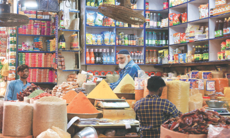 Workers are seen arranging commodities at a spice and grocery shop in Karachi.&mdash;Reuters/File