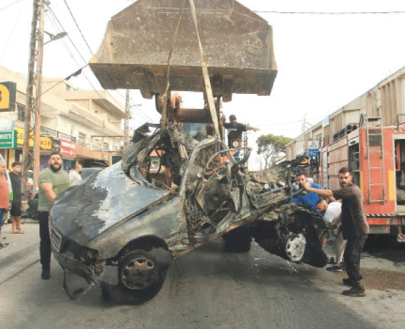 A bulldozer removes the wreckage of a vehicle targeted by an Israeli drone strike in Nabatieh, south Lebanon.&mdash;AFP