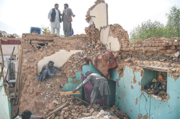 Afghan earthquake survivors search through the remains of a damaged house at a village in Tashqurghan, in the Khulm district of Samangan province.—AFP