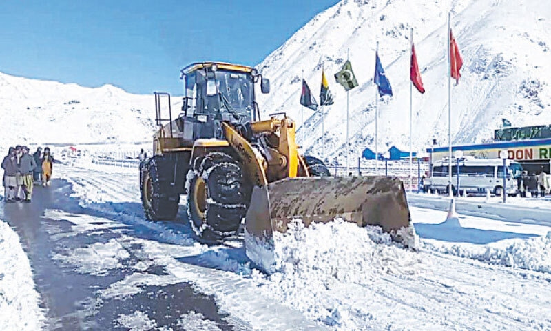 A machine removes snow from MNJ Road in Basel area of Kaghan valley, Mansehra, on Wednesday. &mdash; Dawn