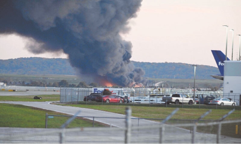 FIRE and smoke mark the place where the cargo plane crashed in Kentucky.—AFP FIRE and smoke mark the place where the cargo plane crashed in Kentucky.—AFP