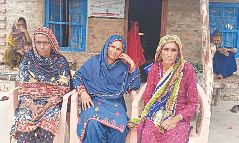 Naushaba (centre) sits alongside her mother (left) and another family member outside her house in Shaikh Soomar village, Sindh, in July 2025 | Photo by the writer