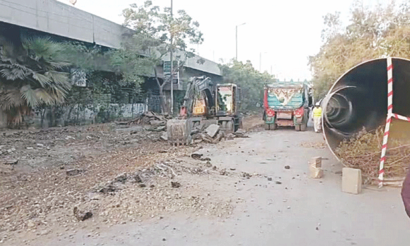 An excavator digs up University Road for the installation of pipes, part of the K-4 water project, as some pipes lie along the roadside.—Dawn An excavator digs up University Road for the installation of pipes, part of the K-4 water project, as some pipes lie along the roadside.—Dawn