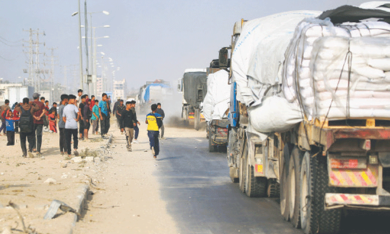 DISPLACED Palestinians chase after trucks carrying food supplies near Deir al-Balah in the central Gaza Strip.—AFP DISPLACED Palestinians chase after trucks carrying food supplies near Deir al-Balah in the central Gaza Strip.—AFP