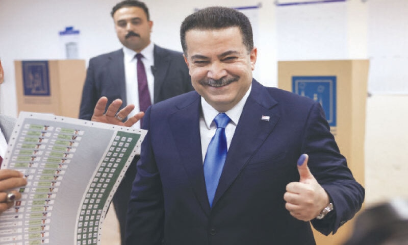 Iraqi Prime Minister Mohammed Shia al-Sudani shows his ink-stained thumb after voting at a polling station.&mdash;Reuters