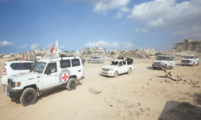 Red Cross personnel, escorted by Hamas fighters, head towards an area within the &ldquo;yellow line&rdquo; in Gaza to which Israeli troops withdrew under the ceasefire agreement.&mdash;Reuters