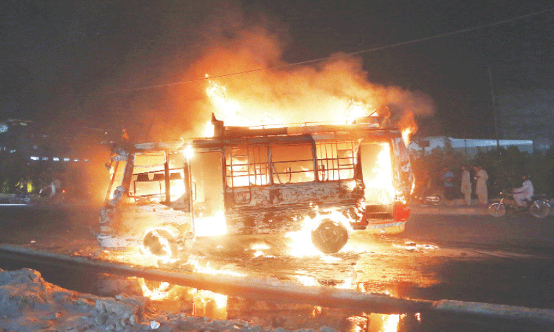 The bus is engulfed in flames after an enraged mob set fire to it following a fatal accident in Korangi. &mdash;Shakil Adil / White Star