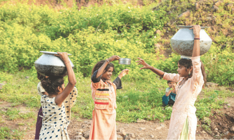 SANGITA Santosh (right), who dropped out of school to manage household chores, walks home with her sister after fetching pots of water from a village in the drought-prone district of Nandurbar, Maharashtra.&mdash;AFP