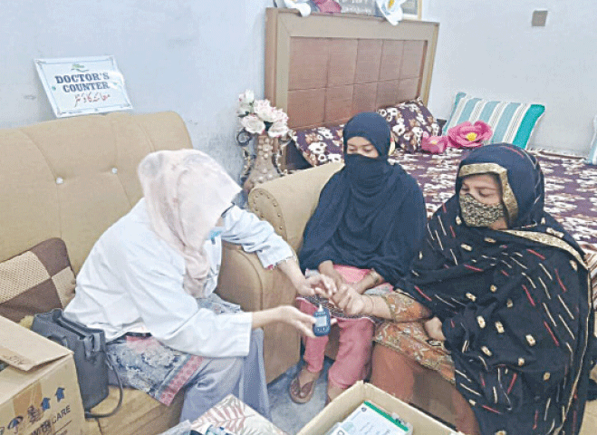 Patients are being attended at home by a lady doctor of clinic on wheels.