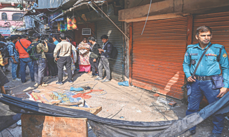 REPORTERS and police personnel stand around rubble that fell from a damaged building following an earthquake in Old Dhaka.—AFP / file