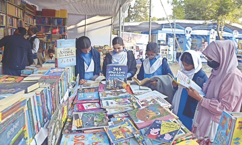 Students read books at a stall during the three-day 11th National Book Festival in Lok Virsa in Islamabad on Tuesday. &mdash; Photos by Mohammad Asim