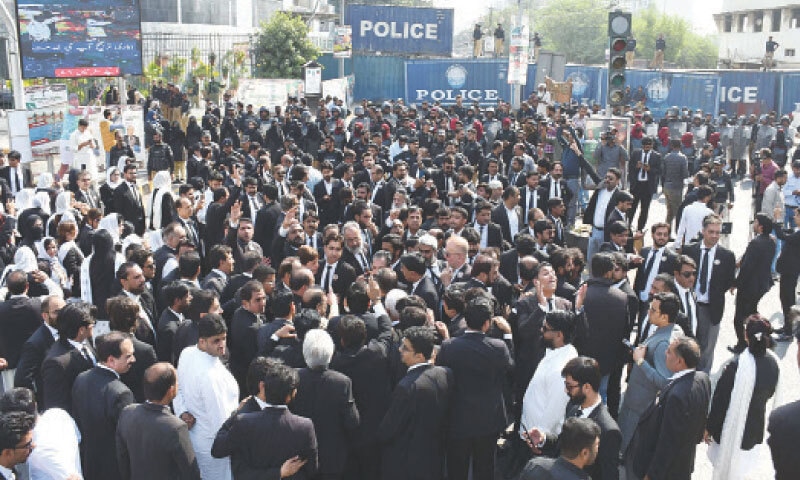 Lawyers stage a sit-in at the PIDC traffic intersection after police placed containers to stop access to the road leading to the Sindh CM House.—Online Lawyers stage a sit-in at the PIDC traffic intersection after police placed containers to stop access to the road leading to the Sindh CM House.—Online