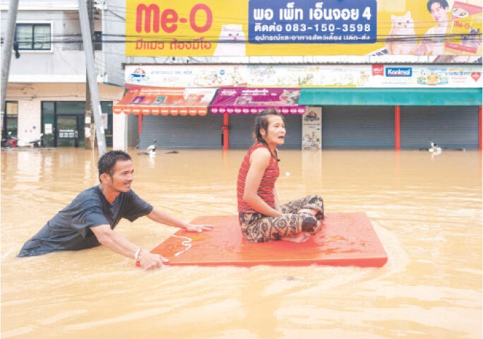 A MAN transports a woman through floodwaters in Thailand&rsquo;s Songkhla province.&mdash;AFP