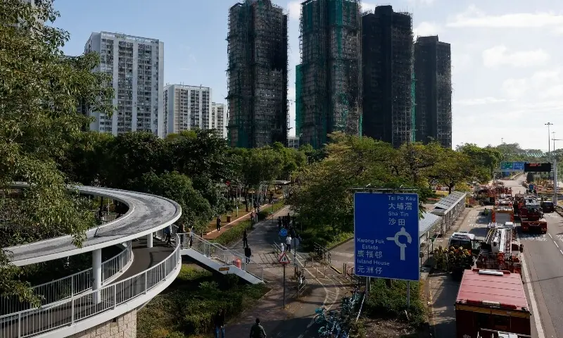 People walk near the buildings of the Wang Fuk Court housing complex after the deadly fire, in Tai Po, Hong Kong, China, December 2, 2025. &mdash;Reuters