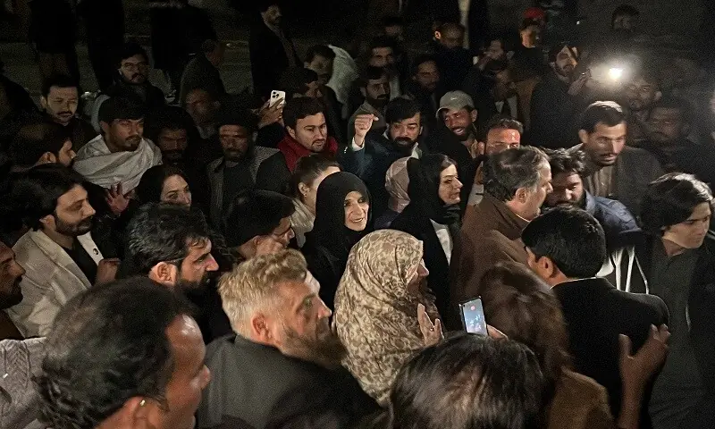 Uzma Khanum, one of the three sisters of the jailed former Prime Minister of Pakistan Imran Khan, walks with party supporters after she meets with Imran, outside Adiala jail in Rawalpindi. &mdash; Reuters
