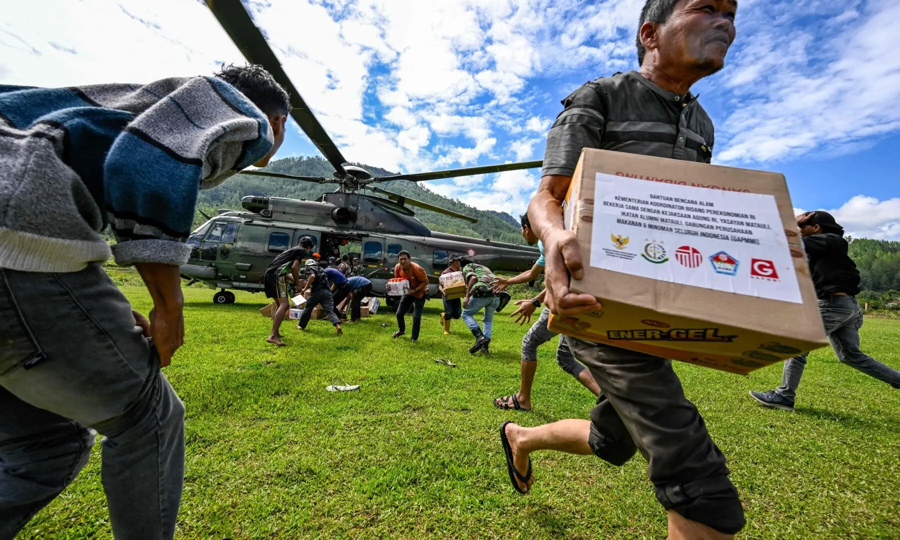 Residents carry supplies distributed by Indonesian air force personnel in flood affected areas in Bener Meriah district, Aceh province on Dec 4, 2025. — AFP