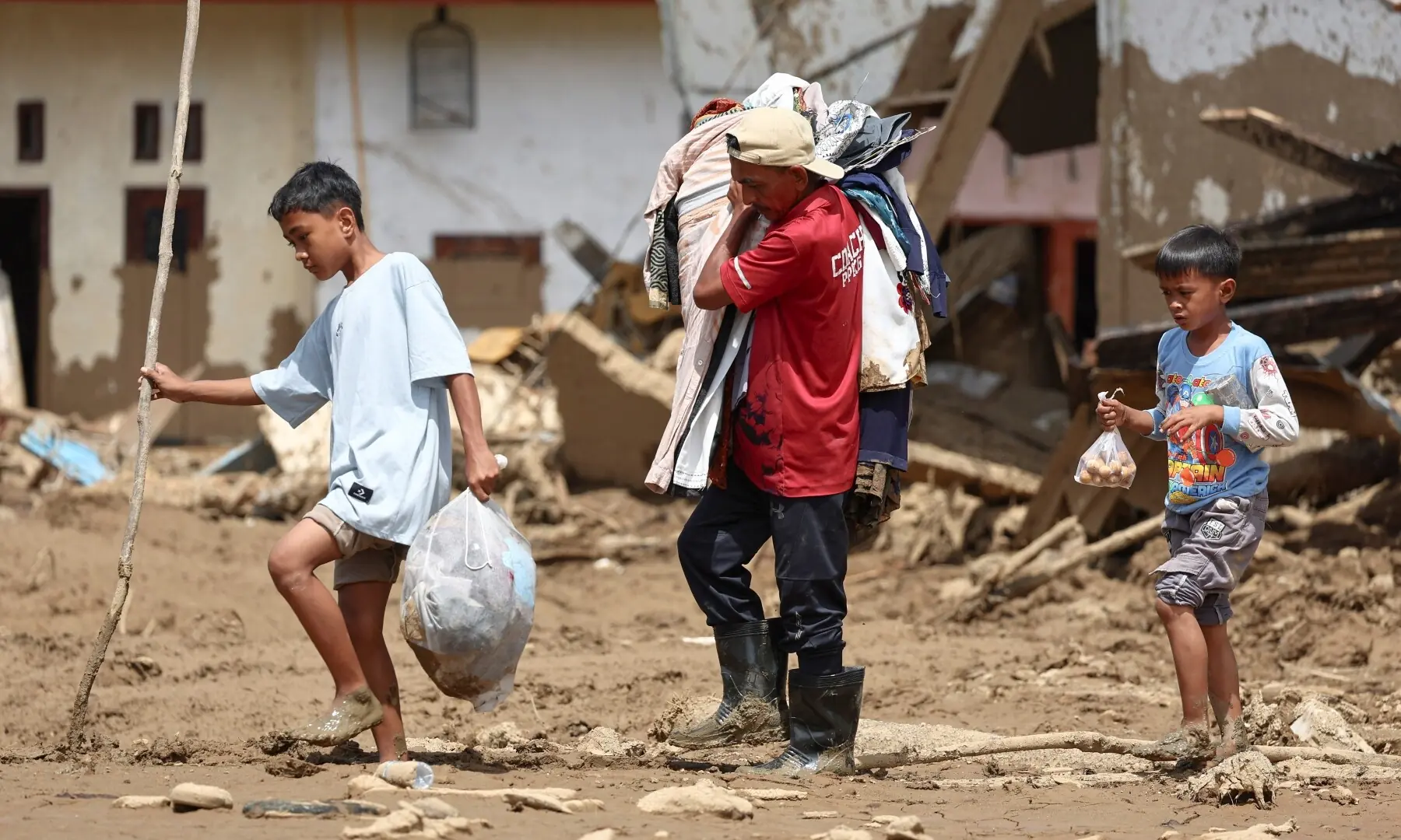 Survivor Ilyasak Imam Mudo, 53, along with his children, collect valuable items from their heavily damaged home West Sumatra province, Indonesia, December 4, 2025. —Reuters Survivor Ilyasak Imam Mudo, 53, along with his children, collect valuable items from their heavily damaged home West Sumatra province, Indonesia, December 4, 2025. —Reuters
