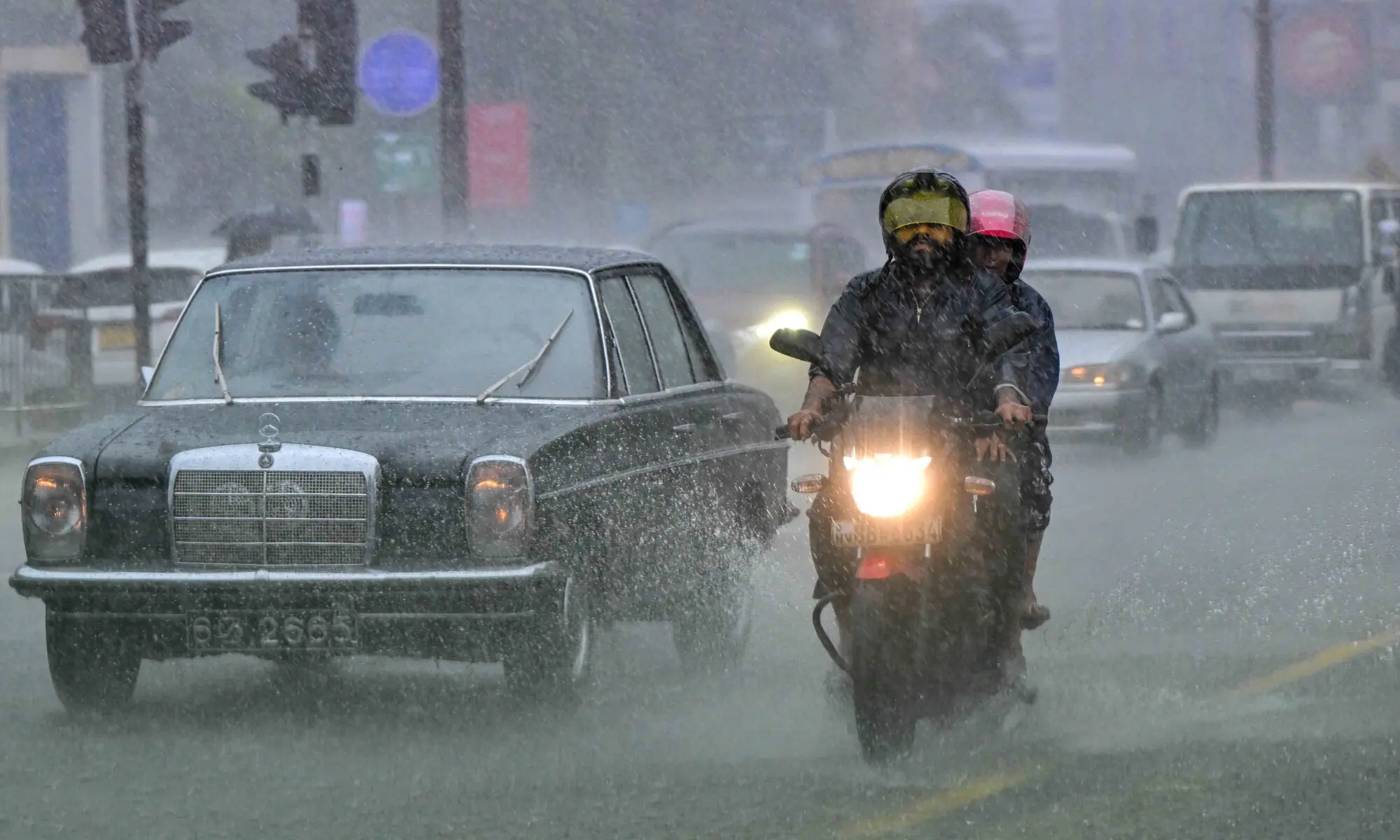 Commuters drive through a flooded street amid heavy rains in Colombo on December 5, 2025. &mdash; AFP