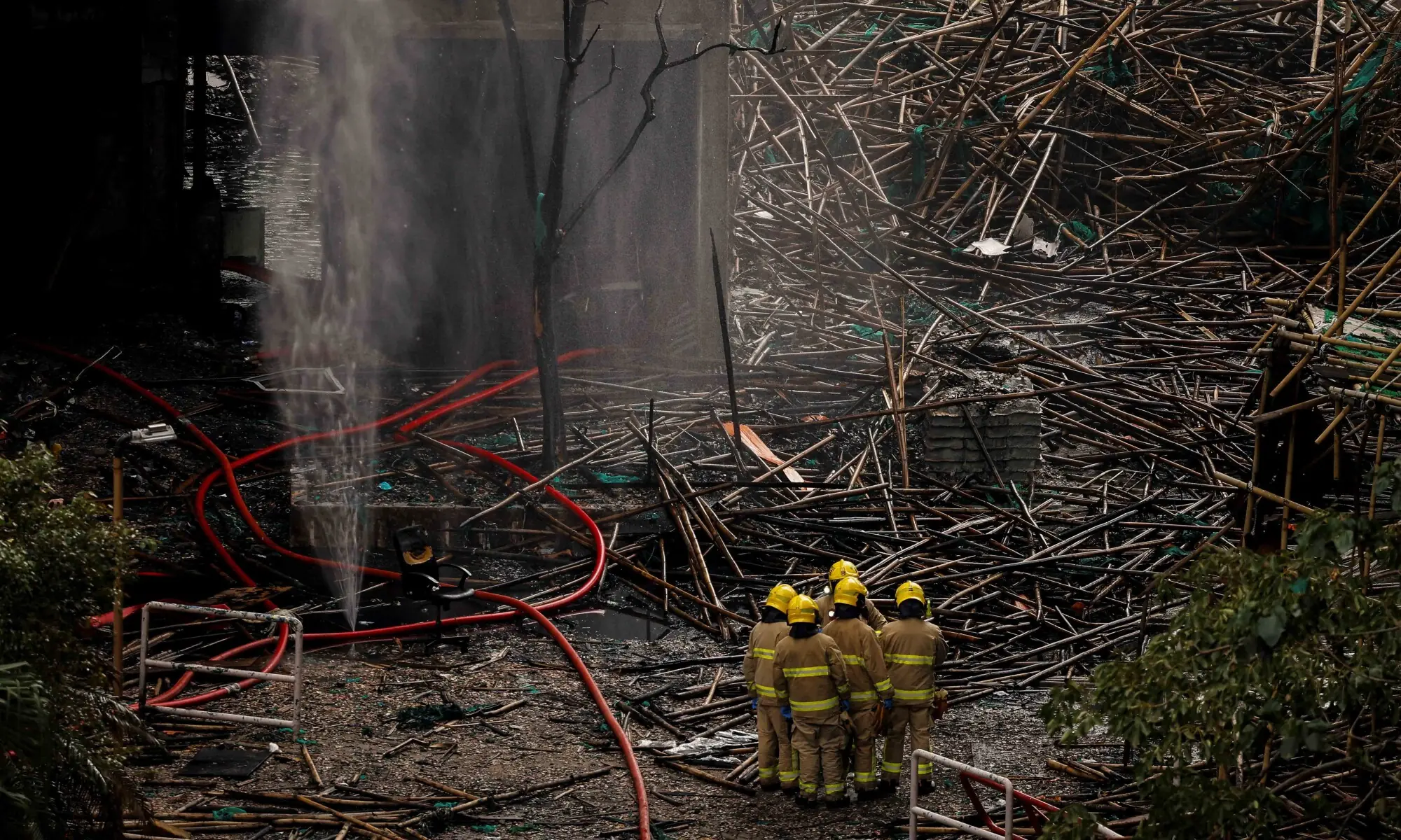 Firefighters gather next to bamboo scaffolding debris at the Wang Fuk Court housing complex after the deadly fire, in Tai Po, Hong Kong, China, December 1, 2025. — Reuters