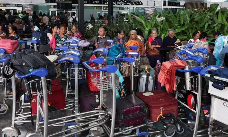 Travellers sit with their luggage at Kempegowda International Airport in Bengaluru, India, December 6. &mdash;Reuters