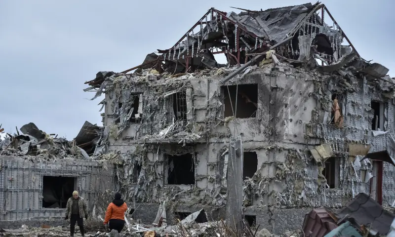 People stand near a building hit during the Russian missile and drone strike, amid Russia&rsquo;s attack on Ukraine, in the town of Slobozhanske, Dnipro region, Ukraine on December 6, 2025. &mdash; Reuters