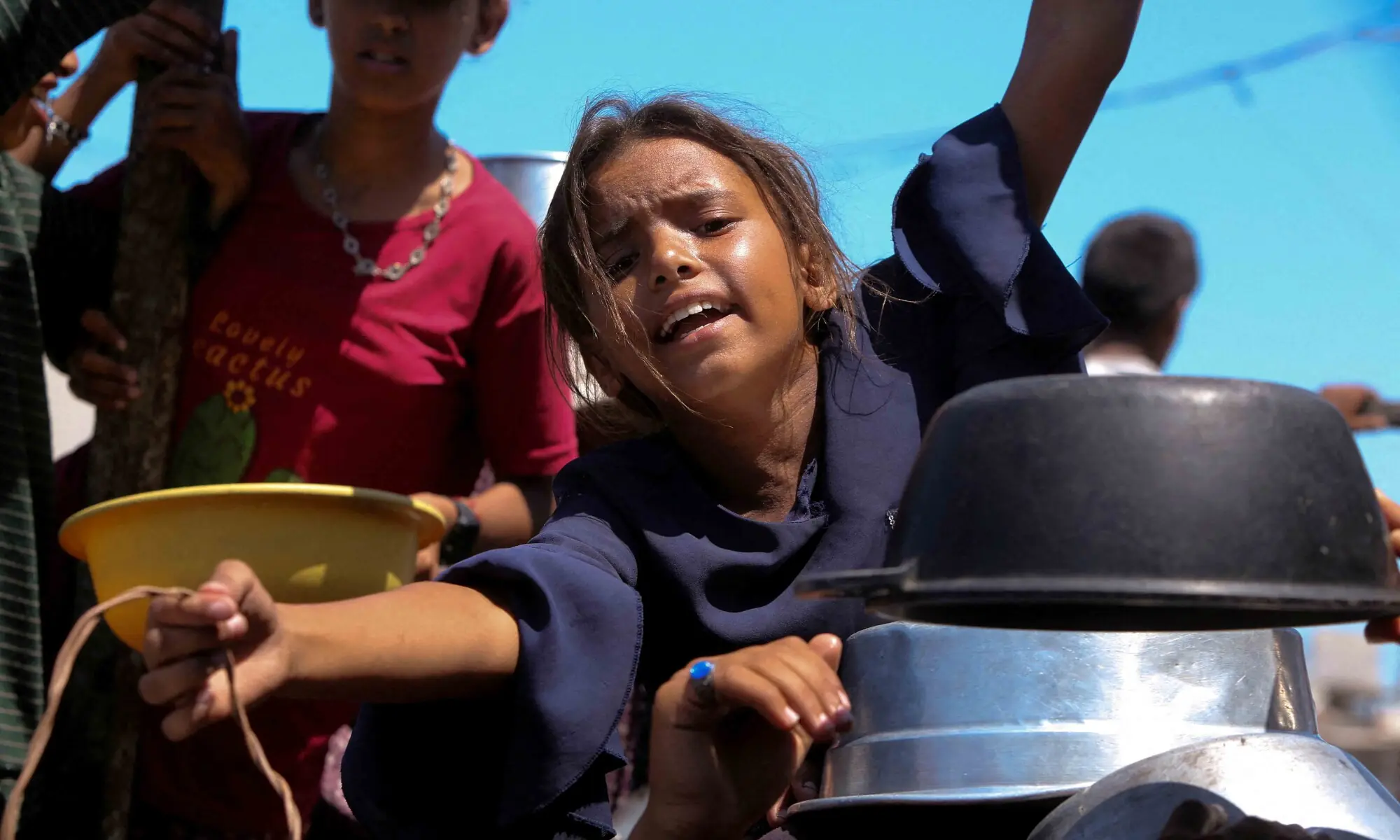 A Palestinian girl gestures as she waits to receive food from a charity kitchen, amid a hunger crisis, in Khan Younis, southern Gaza Strip, August 4, 2025. — AFP A Palestinian girl gestures as she waits to receive food from a charity kitchen, amid a hunger crisis, in Khan Younis, southern Gaza Strip, August 4, 2025. — AFP