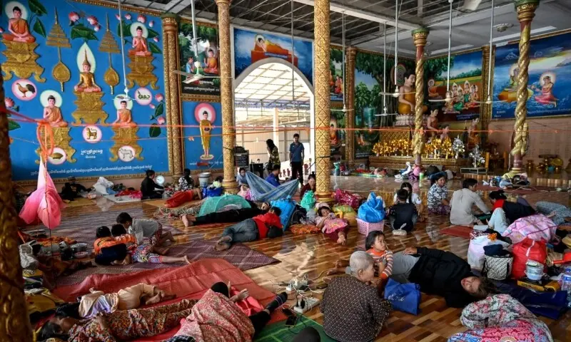  Residents rest inside a temple after they evacuated following clashes along the Cambodia-Thailand border, in Siem Reap province on December 9. &mdash; AFP 