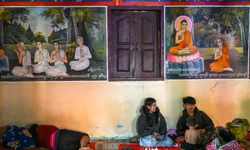  Residents rest inside a temple after they evacuated following clashes along the Cambodia-Thailand border, in Siem Reap province on December 9. — AFP 
