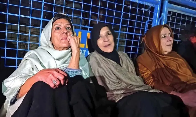 Aleema Khan, sister of PTI founder Imran Khan, sits in front of a police barricade in Rawalpindi on December 9. — X/@PTIofficial
