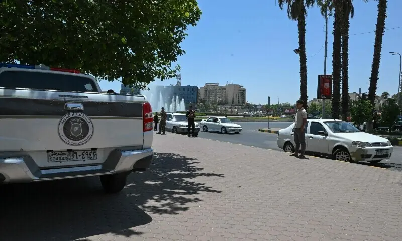 Syrian youths stand on an empty pavement near the military headquarters in Damascus&rsquo; Ummayad Square, after Israel said it hit the nearby military spot, July 16. &mdash; AFP/ File
