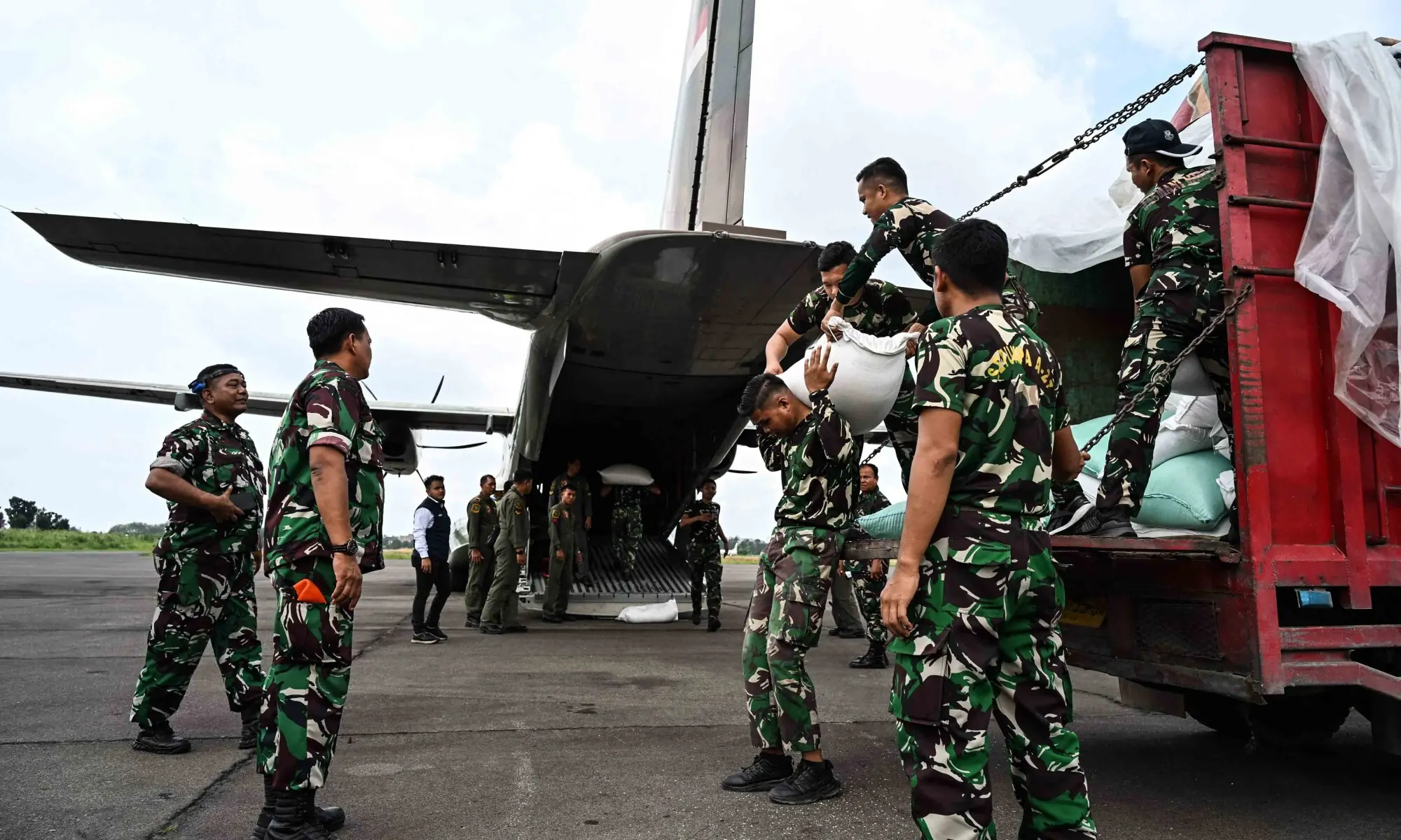 Indonesian military personnel move sacks of rice to load them onto an aircraft as part of relief supplies to be delivered to flood-affected areas in North Sumatra and Aceh, at Soewondo Air Base in Medan, North Sumatra, on December 12, 2025. &mdash; AFP