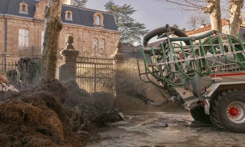 A tractor sprays liquid manure on the facade of Millau&rsquo;s sub-prefecture during a farmers&rsquo; protest against the policy of slaughtering cows with Contagious Nodular Dermatosis on Sunday.&mdash;AFP
