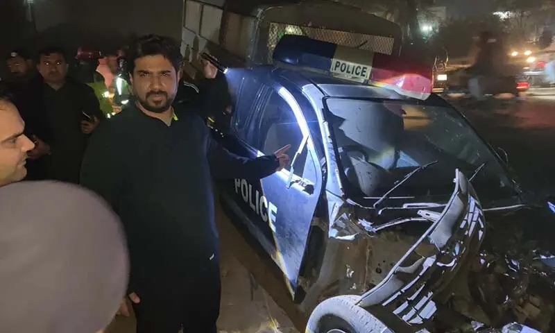 Officials gather around the wreck of a police van that was struck by a train in Sargodha on December 15. &mdash; Photo via author