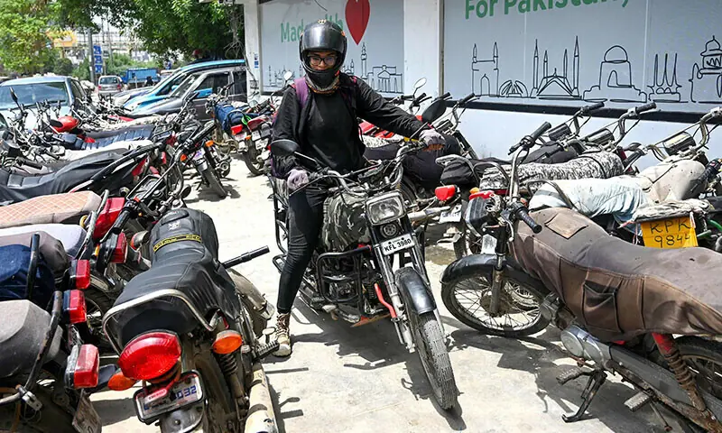 In this photograph taken on August 19, 2024, Amina Sohail, a motorbike rider with a local ride-hailing service provider Bykea, leaves to deliver parcels in Karachi. Used for representation only. &mdash; AFP