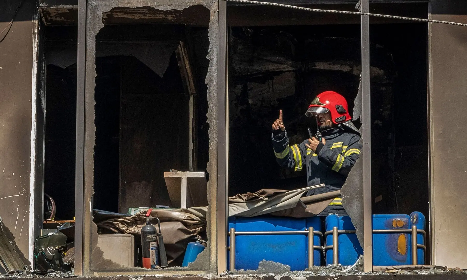 A firefighter works inside the burnt and vandalised building of the Prothom Alo newspaper in Dhaka on December 19, 2025. &mdash; AFP