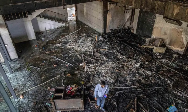 A man walks through the burnt office of The Daily Star newspaper in Dhaka on December 19, 2025, amid protests following the news of the death of youth leader Sharif Osman Hadi. — AFP A man walks through the burnt office of The Daily Star newspaper in Dhaka on December 19, 2025, amid protests following the news of the death of youth leader Sharif Osman Hadi. — AFP