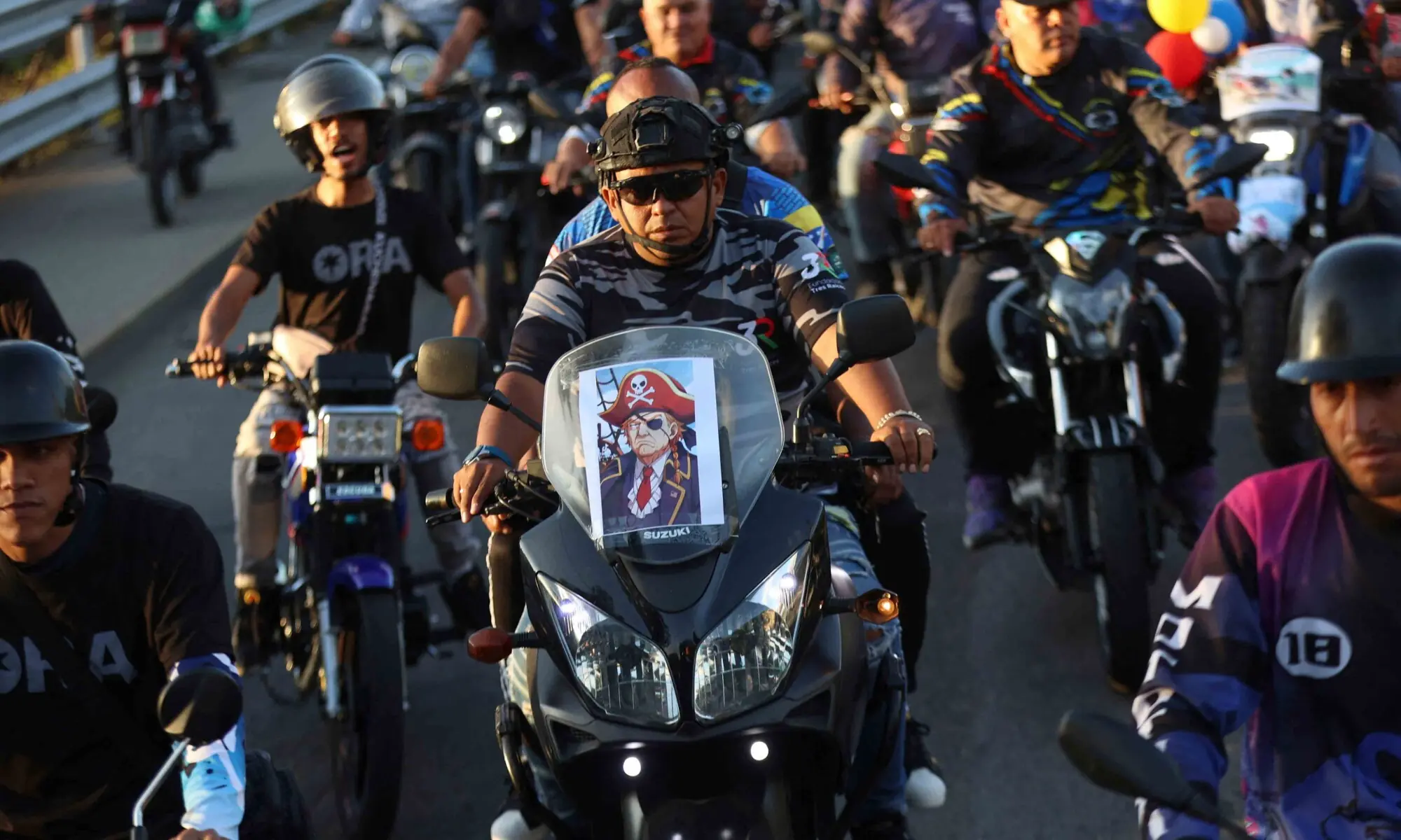 A motorcyclist with an image of US President Donald Trump dressed as a pirate attached to his bike takes part in a motorcade to protest against the United States in Caracas on December 22, 2025. &mdash; AFP