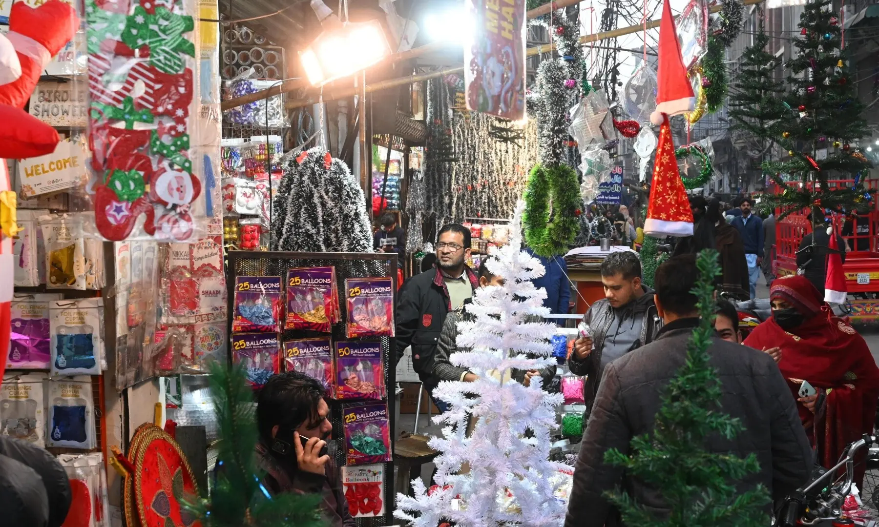People shopping for Christmas items on Ganpat Road, Lahore. &mdash; Arif Ali
