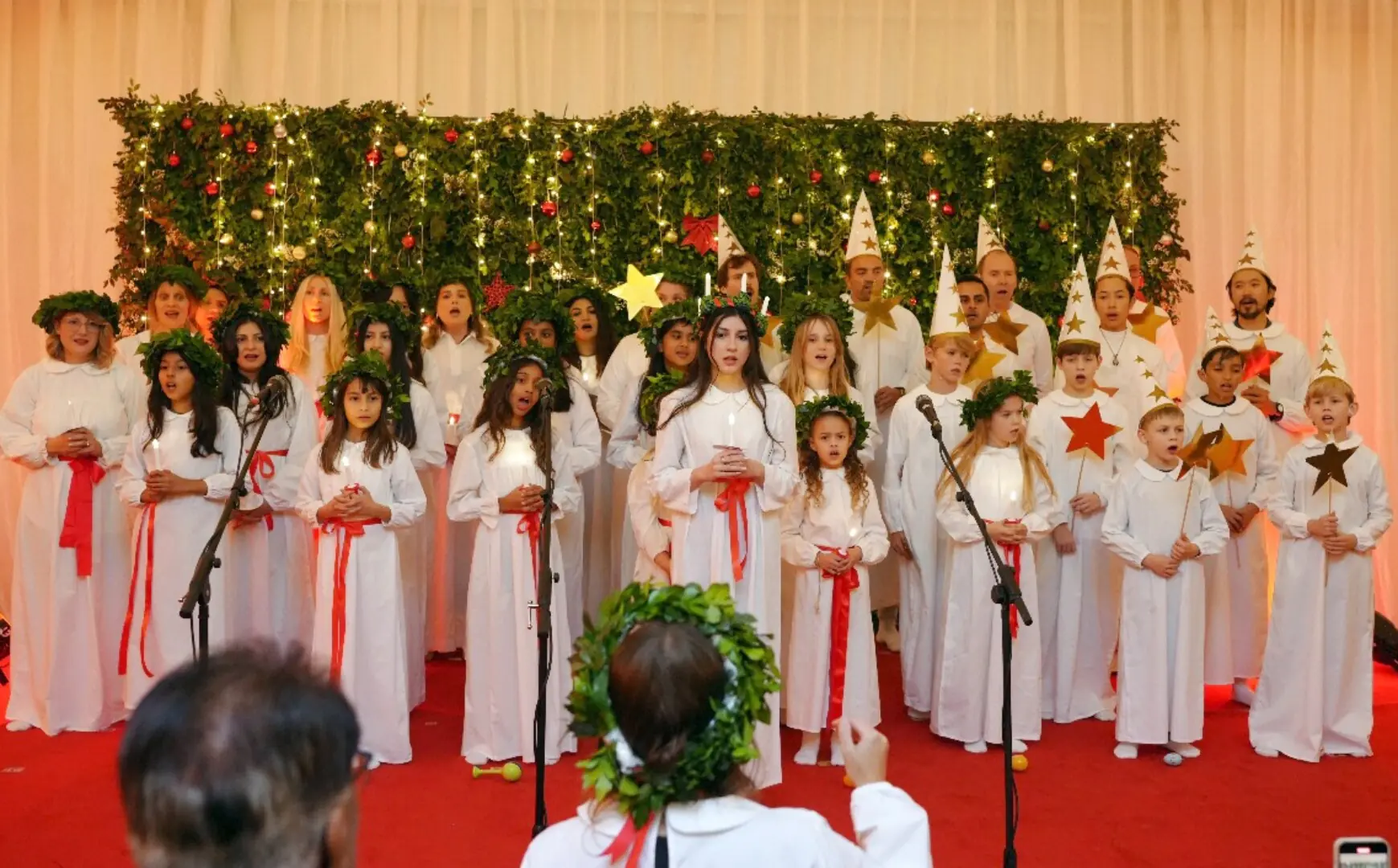 Members of the Swedish and Nordic community hold candles as they sing songs during the Lucia Festival organised by the Swedish embassy in Islamabad on. &mdash; Mohammad Asim/White Star
