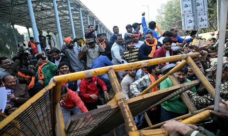 Vishva Hindu Parishad (VHP) activists along with others topple a barricade during a protest near the Bangladesh High Commission in New Delhi on December 23. &mdash;AFP