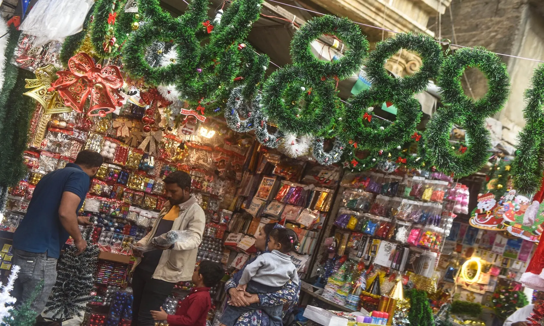 A shop displays Christmas ornaments in Karachi as customers inspect them. &mdash; Fahim Siddiqui/ White Star