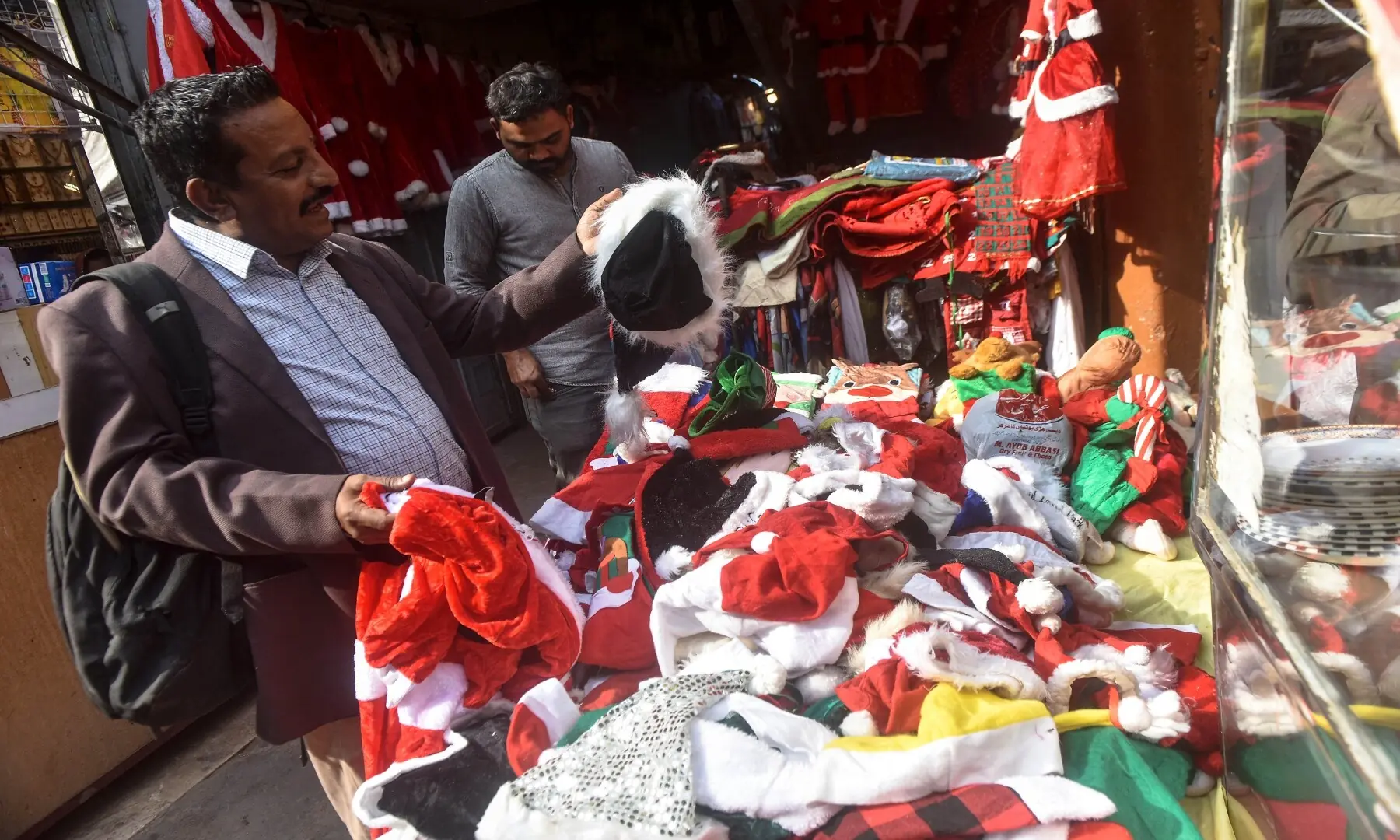 People purchase Christmas costumes from a roadside stall in a busy Karachi market. &mdash; Fahim Siddiqui/ White Star
