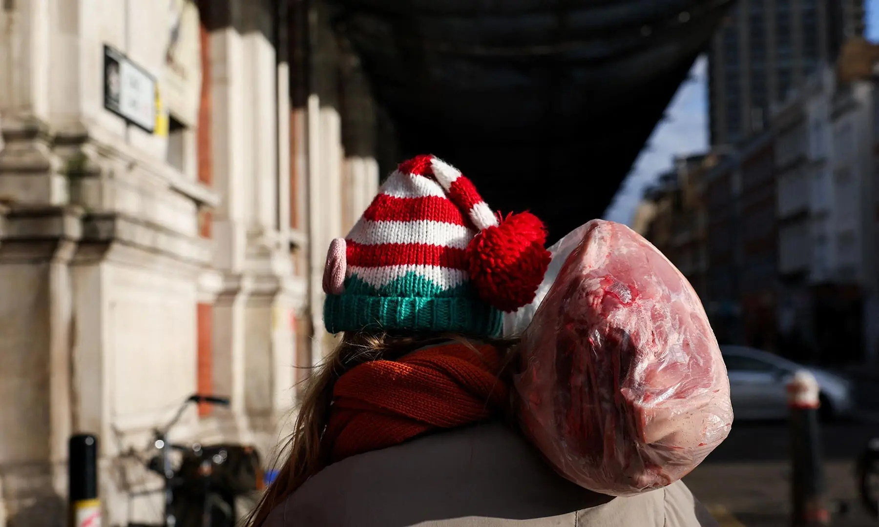 A person wearing a festive hat carries a cut of meat at a pre-Christmas auction in Smithfield Market in London, the UK on December 24. &mdash; Reuters