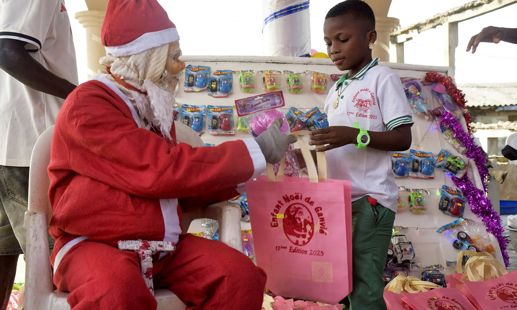 A man dressed as Santa Claus distributes gifts during a gift-giving tour in the floating village of Ganvie ahead of the holiday celebrations in Cotonou, Benin on December 23. &mdash; Reuters