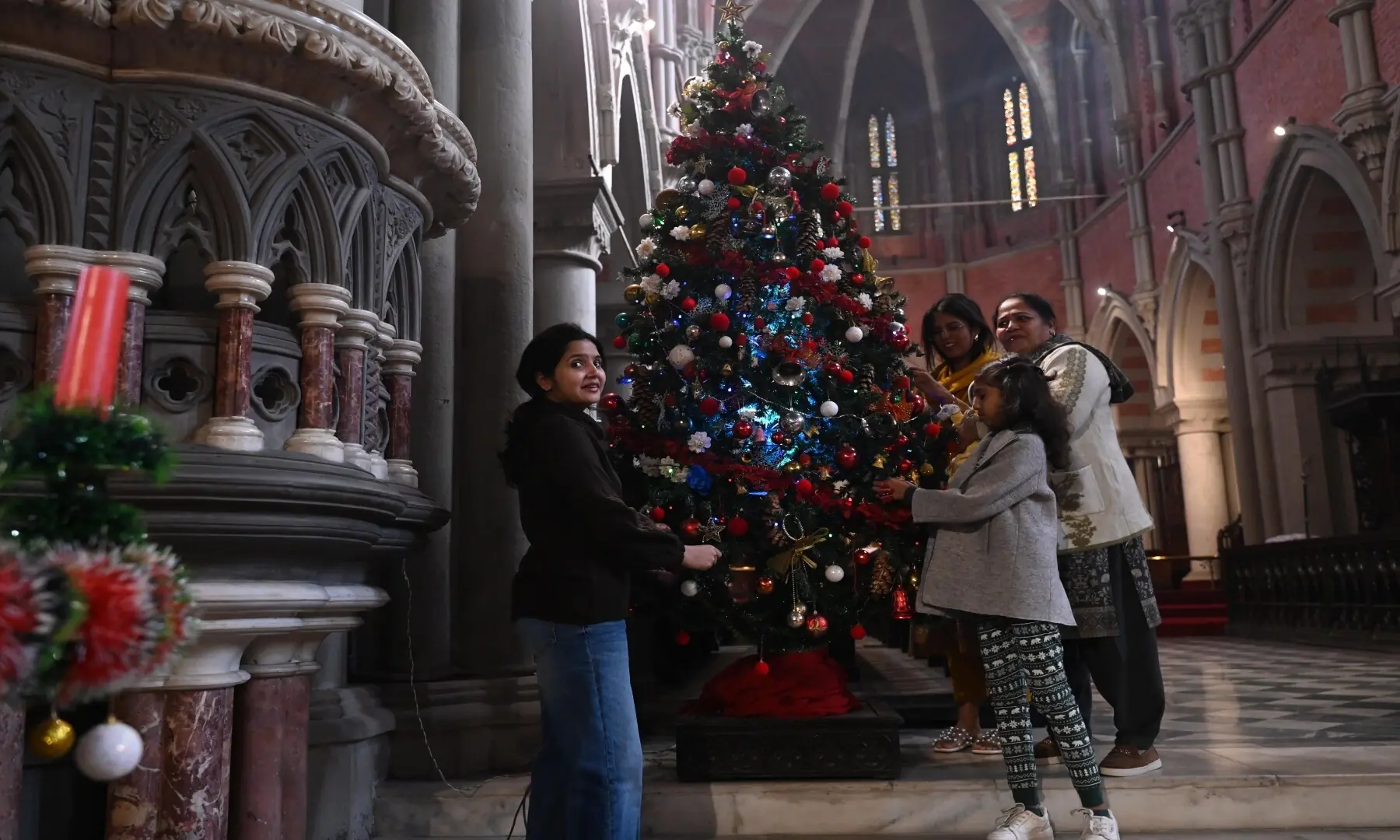 People decorating a Christmas tree at a Lahore cathedral church. &mdash; Arif Ali / Lahore
