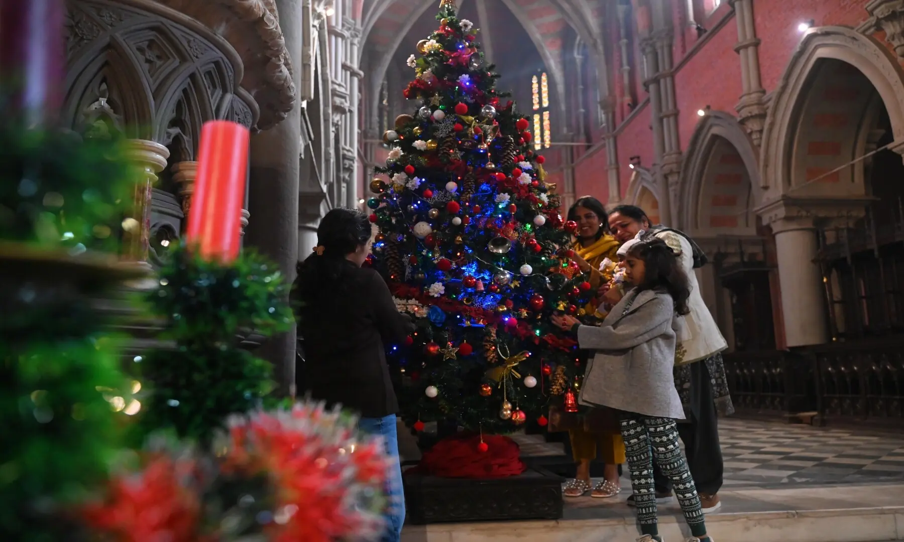 People decorating a Christmas tree at a Lahore cathedral church. &mdash; Arif Ali / Lahore