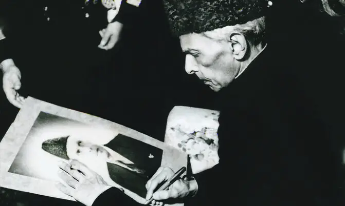 In this rare meta-image, Quaid-i-Azam Mohammad Ali Jinnah autographs his portrait at a reception held in Karachi in December 1947. | Photo: The Press Information Department, Ministry of Information, Broadcasting & National Heritage, Islamabad (PID) In this rare meta-image, Quaid-i-Azam Mohammad Ali Jinnah autographs his portrait at a reception held in Karachi in December 1947. | Photo: The Press Information Department, Ministry of Information, Broadcasting & National Heritage, Islamabad (PID)